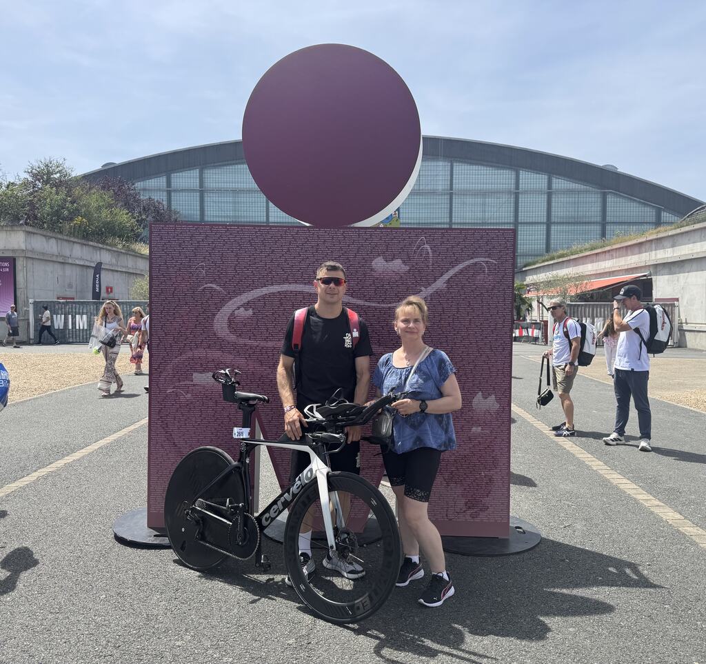 Tomek z mamą i rowerem Cervelo przy Ironman Tours backdrop